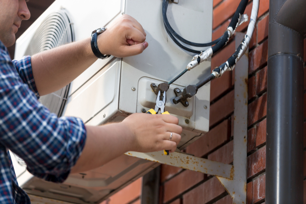 Closeup of male technician repairing outdoor air conditioner unit Klíma tisztítás, klima tisztírtás, Klíma tisztítás Pécs, klima tisztírtás Pécs