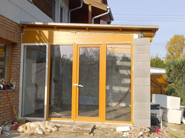 Télikert építése Pécsen diófóliás műanyag nyílászárókkal, hőszigetelt üveg toló-bukó ajtóval és üvegtetővel, RID Solutions Kft. kivitelezés.